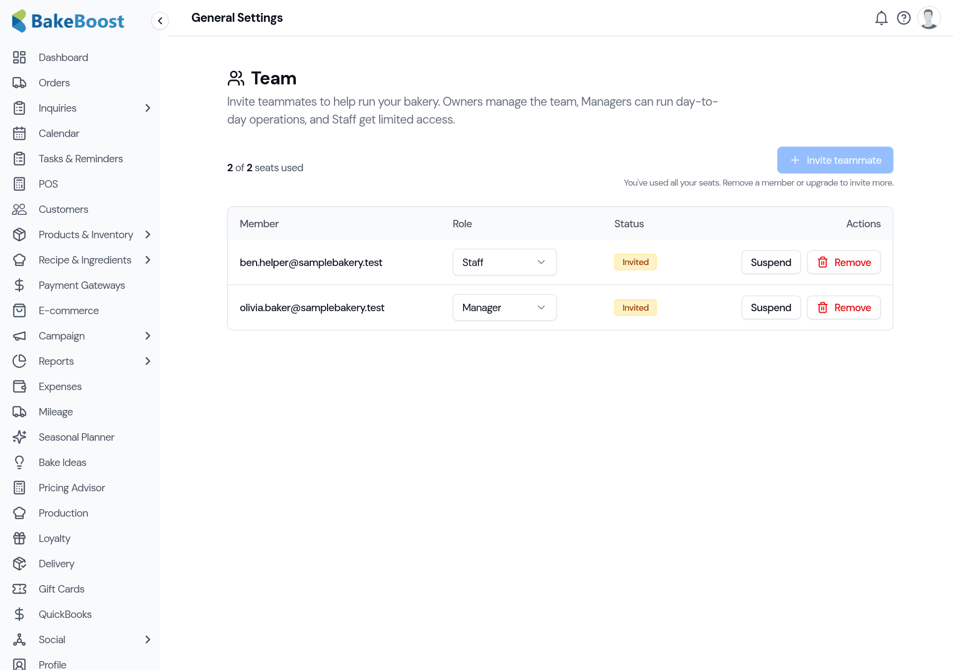 The Team settings page: a seat counter (2 of 2 seats used), an Invite teammate button, and a table of members each showing their email, a role dropdown (Staff / Manager), an Invited status, and Suspend / Remove actions.